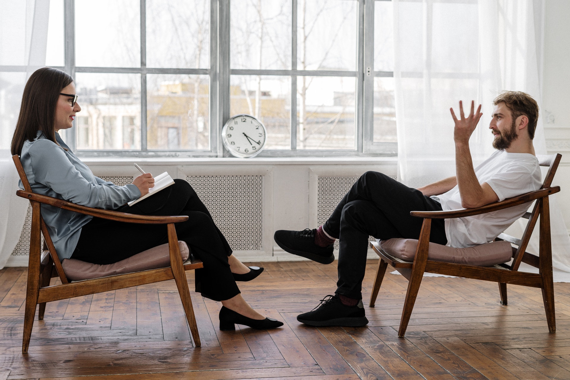 A female therapist sits across from a male who seems to be in the middle of explaining something to her.